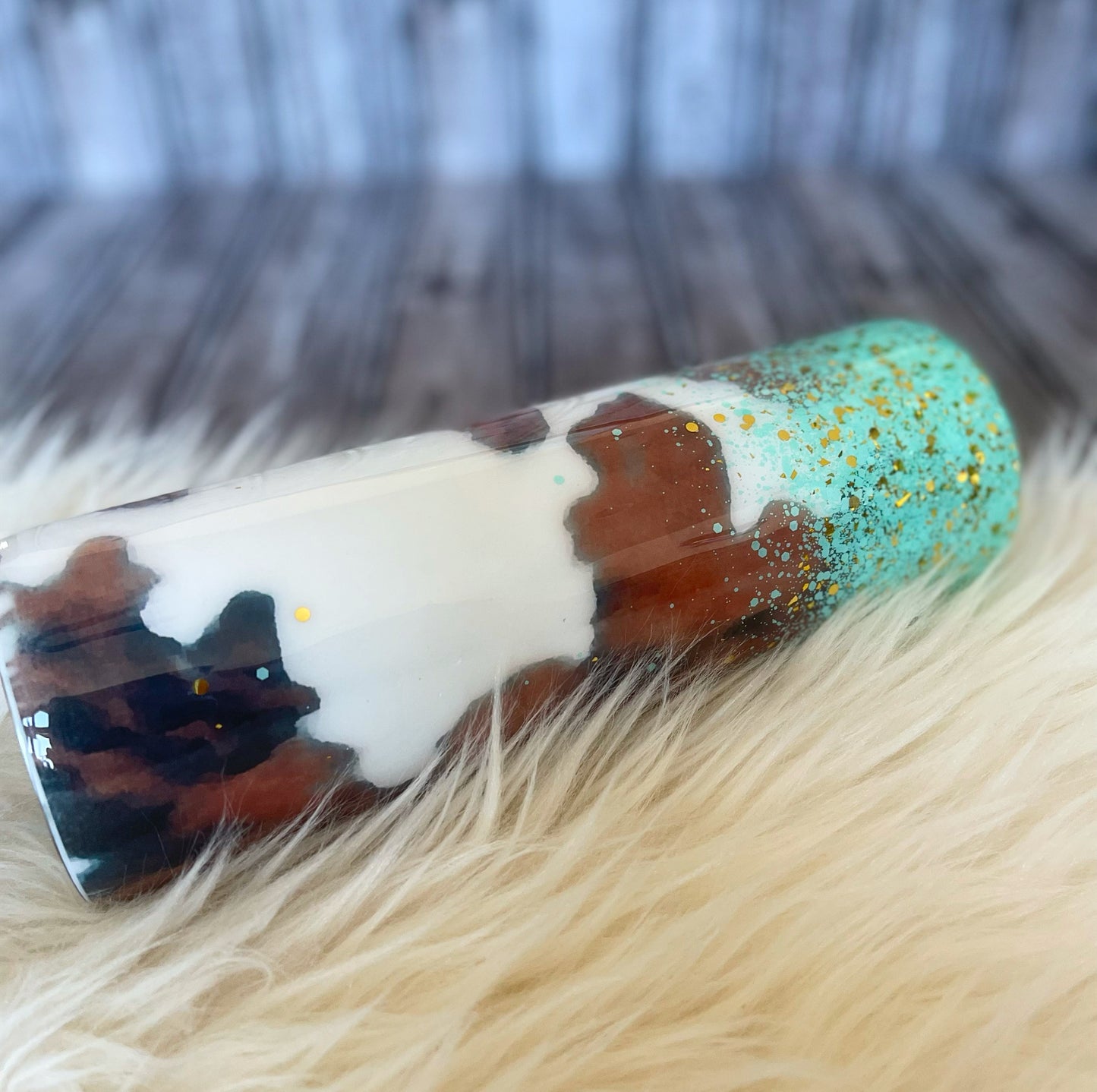 Cowhide tumbler with turquoise and gold glitter.